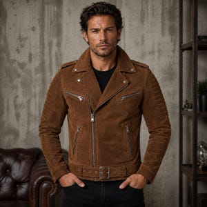 May include: A brown suede motorcycle jacket featuring a wide notched collar, silver-tone metal zippers on the chest and sides, shoulder epaulets, and a matching adjustable belt with a silver buckle at the waist, worn over a plain black shirt.