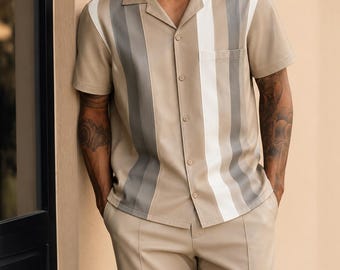 Op de afbeelding: Een overhemd met korte mouwen en knoopsluiting, voorzien van een verticaal streeppatroon in beige, witte en grijze tinten. Het overhemd heeft een klassieke kraag, een enkele borstzak aan de linkerzijde en een knoopsluiting aan de voorzijde.