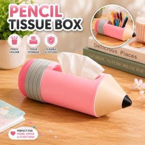 Puede incluir: Una caja de pañuelos con forma de lápiz rosa, con una sección de goma gris y una punta color canela con un extremo negro. El cuerpo principal presenta una abertura rectangular para dispensar pañuelos. Un recuadro circular muestra el portalápices.