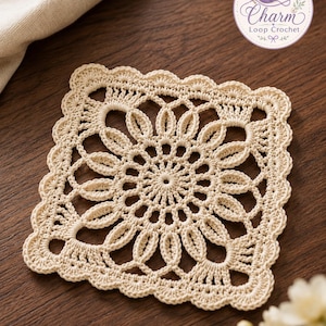 May include: A square cream-colored crochet doily featuring an intricate floral-inspired openwork pattern with a scalloped edge. A circular logo in the top right corner displays a purple yarn ball and the text Charm Loop Crochet.