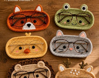 May include: Six oval crochet glasses holders featuring animal designs including a fox, frog, chick, cat, hedgehog, and deer. Each holder has black bead eyes and holds a pair of eyeglasses. Text reads: 6 Crochet Glasses Holder Patterns Animal Bundle.