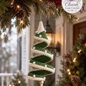Op de afbeelding: Een spiraalvormig kerstboomornament gemaakt van donkergroen en crèmekleurig garen. Het ontwerp heeft een gedraaide structuur met crèmekleurige randen die zijn geaccentueerd met kleine witte kralen. Een houten kraal hangt aan het onderste punt.