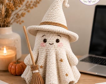 May include: A cream-colored crocheted ghost figurine wearing a pointed witch hat with a brown band. The ghost has embroidered eyes, a small smile, pink cheeks, and three small brown stars on its body. It holds a small brown yarn broom.