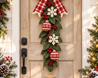 May include: A crochet Christmas door swag featuring a large red and white plaid bow at the top. The swag is composed of green crocheted leaves, red pom-poms, two white crocheted snowflakes, two red and white patterned crochet ornaments, and a gold star.