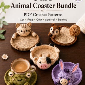 May include: A collection of five handmade crochet animal coasters: a cat, frog, cow, squirrel, and donkey. Each coaster is a different color and design, with the animal's face and features prominently displayed. The frog coaster holds a cup of coffee. The text "5 in 1 Animal Coaster Bundle" is at the top.