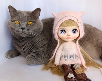 Suéter y gorro con orejas de gato para muñeca Blythe, tejidos a mano, con motivo de gato en hilo rosa y detalle de botón con forma de huella.