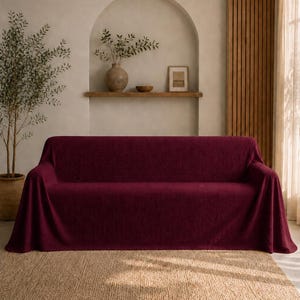 May include: A deep burgundy sofa cover with a textured, fabric finish that drapes over the entire frame of the couch. The cover features a consistent, solid dark red color and a soft, slightly ribbed surface texture that extends to the floor.