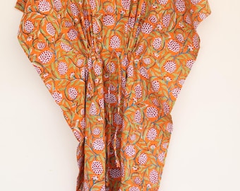 Puede incluir: Un vestido caftán de color naranja vibrante con un patrón repetitivo de motivos florales circulares rosas y enredaderas verdes. La prenda tiene un escote en V, mangas cortas anchas y un cordón en la cintura que frunce la tela.