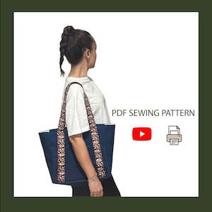 May include: A navy blue tote bag with long, patterned straps featuring a colorful floral design. The bag is shown alongside the text PDF SEWING PATTERN, a red YouTube play button icon, and a printer icon, indicating a digital sewing project.