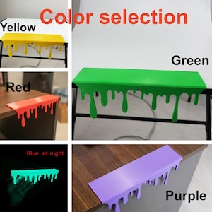 Pu&ograve; includere: Una selezione di protezioni per bordi scrivania colorate in giallo, rosso, verde, blu e viola. Le protezioni hanno un design a goccia unico e sono mostrate su diverse superfici. Il testo "Color selection" &egrave; visualizzato in alto.