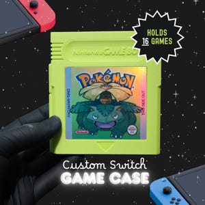 May include: A lime green custom game case shaped like a vintage Game Boy cartridge. The centre label features a holographic illustration of the Pokémon Venusaur with the text Pokémon, DMG-WKPR-UKV, and THIS SIDE OUT. A starburst graphic states HOLDS 16 GAMES.