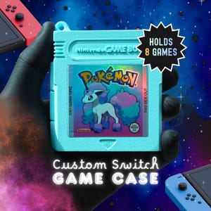 May include: A light blue plastic game cartridge case shaped like a classic handheld console game, featuring a holographic Pokémon label with a unicorn-like creature. The case includes text stating HOLDS 8 GAMES and Custom Switch GAME CASE.