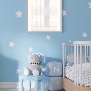 Könnte beinhalten: Ein gerahmtes "Monatlicher Schlaftracker"-Diagramm hängt an einer blauen Wand mit weißen Sternaufklebern. Ein grauer Teddybär sitzt auf einem hellblauen Stuhl neben Buchstabenblöcken.