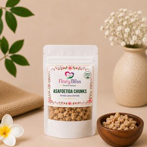 May include: A white stand-up pouch containing light brown asafoetida chunks. The label features the text Flory Bliss, Pure & Natural, ASAFOETIDA CHUNKS, and Ferula assa-foetida, surrounded by a floral border with a 100% natural circular emblem.