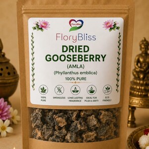 Op de afbeelding: Een bruine kraftpapieren zak met gedroogde kruisbes (amla) stukjes. Het etiket bevat de tekst FloryBliss, DRIED GOOSEBERRY (AMLA), (Phyllanthus emblica), 100% PURE, en iconen met 100% PURE, SMOKELESS, LONG LASTING FRAGRANCE, IDEAL FOR PUJA & AARTI, en ECO FRIENDLY.
