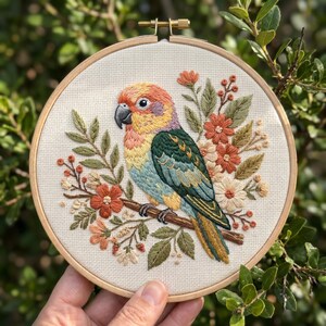 May include: Hand-stitched embroidery art of a colorful parrot perched on a branch, surrounded by flowers and foliage. The parrot features orange, yellow, green, and blue hues. The artwork is displayed in a round wooden embroidery hoop.