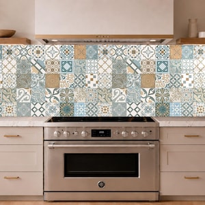 Puede incluir: Un panel rectangular para salpicadero de cocina que presenta una cuadrícula repetitiva de azulejos cuadrados con diversos patrones geométricos y florales en tonos azul claro, beige, blanco y gris oscuro, colocado detrás de una cocina de gas de acero inoxidable.