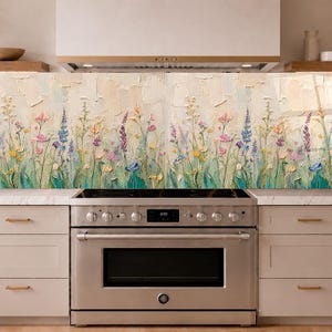以下が含まれることがあります： 野草の牧草地を描いたテクスチャーのあるインパスト画が特徴の長方形のキッチンバックスプラッシュパネル。このアートワークには、クリーム色の背景にピンク、青、黄色、紫の色合いのさまざまなカラフルな花が描かれています。