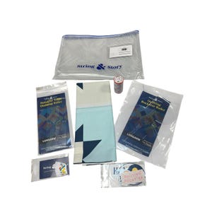 Peut inclure: Un kit de quilting comprenant un sac de rangement en maille transparente avec le texte String & Story, deux règles en plastique transparent étiquetées Straight Edge Quilting Ruler et Quilting Rockstar Ruler, un tissu plié à motifs d'étoiles bleues et des autocollants.