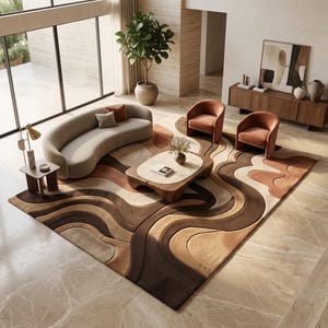 May include: A large area rug featuring a multi-layered, wavy pattern in shades of cream, tan, and dark brown. The rug is positioned in a living room setting with a curved beige sofa, two orange armchairs, and a low wooden coffee table.