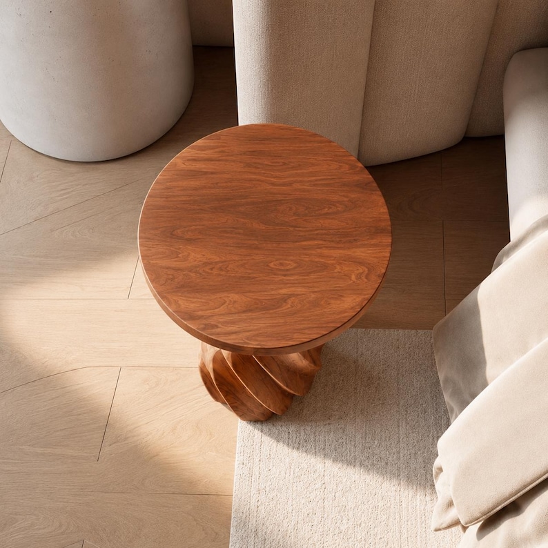 May include: A round side table crafted from medium-toned wood with a visible grain pattern on the circular top. The base features a distinct spiralling, twisted design that supports the flat surface, creating a sculptural form made of solid wood.
