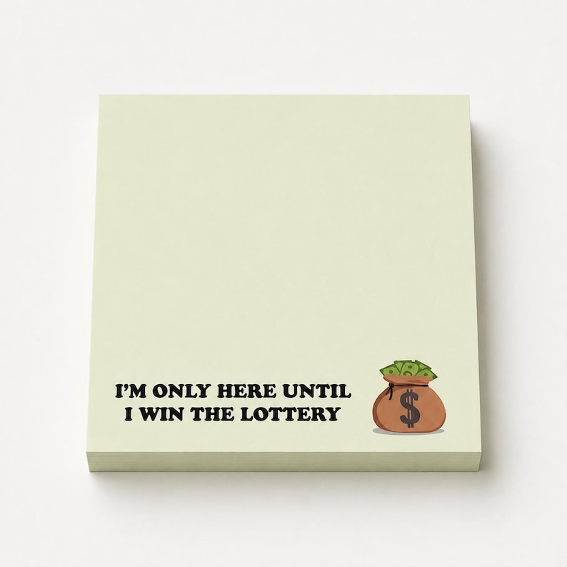 May include: A square, pale yellow sticky note pad featuring the black text "I'M ONLY HERE UNTIL I WIN THE LOTTERY" printed on the bottom left. To the right of the text is a small illustration of a brown money bag filled with green cash.