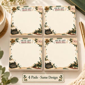 May include: Four square memo pads featuring a cream-colored center with a border of green leaves, small flowers, a vintage typewriter, a fountain pen, and a binder clip. The text PER MY LAST BRAIN CELL is printed at the top of each pad.