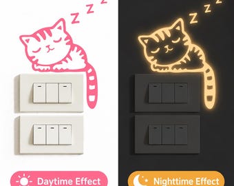 May include: A wall decal featuring a sleeping cat with striped markings and three Z letters above it. The left side shows a pink decal on a white light switch, while the right side shows a glowing yellow version on a black light switch.