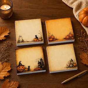 May include: Four square paper note pads with a vintage parchment texture. Each pad features different Halloween illustrations: a ghost and cat, pumpkins, a witch-hat pumpkin and haunted house, and a lantern with a skull and pumpkin.