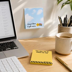 May include: A square yellow sticky note with black text reading "THEY DON'T PAY ME ENOUGH FOR THIS" and "NOT EVEN CLOSE" above a black and yellow hazard stripe pattern, alongside a blue sky sticky note with a cartoon star and rainbow graphic.