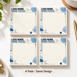 Op de afbeelding: Vier vierkante papieren memoblokken met een crèmekleurige achtergrond, blauwe geometrische accenten en de tekst "LESS NOISE. MORE FOCUS." bovenaan. Elk blok bevat een rasterpatroon, cirkels en de woorden "NOTES, IDEAS, PLANS, PROGRESS" onderaan.