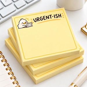 以下が含まれることがあります： 濃い茶色の縁取りと上部に「URGENT-ISH」という文字が印刷された、正方形の薄い黄色の付箋の束。一番上のシートのテキストの左側には、ノートパソコンの前に座っている白い鳥の小さなイラストが描かれています。