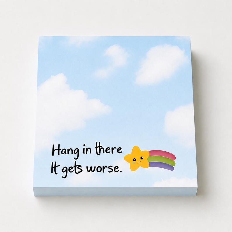 May include: A square notepad featuring a light blue sky background with white clouds. The text "Hang in there It gets worse." is printed in black. To the right of the text is a small, smiling yellow star with a colorful rainbow trail behind it.