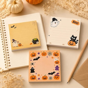 Könnte beinhalten: Drei quadratische Haftnotizblöcke mit Halloween-Motiven. Einer zeigt einen Geist, einen Kessel und Fledermäuse auf gelbem Grund. Ein weiterer enthält einen Geist, eine schwarze Katze und den Text BOO! auf cremefarbenem Grund. Der dritte hat einen Kürbisrand.