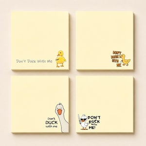 Può includere: Quattro blocchetti di note adesive quadrati color giallo pallido. Ogni blocchetto presenta un'illustrazione unica di un'anatra o un'oca che tiene un coltello e il testo Don't Duck With Me in vari stili, incluso uno con occhiali da sole.