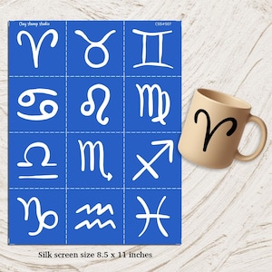 May include: A blue silk screen with white zodiac symbols and a beige mug with the Aries symbol. The silk screen is 8.5 x 11 inches. The mug has a black Aries symbol.