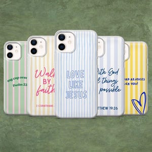 May include: Five smartphone cases featuring vertical stripes in pastel colors. Each case displays unique religious text: 'my cup over', 'Walk BY faith', 'LOVE LIKE JESUS', 'With God all things possible', and 'LORD REJOICES OVER YOU' with a blue heart outline.