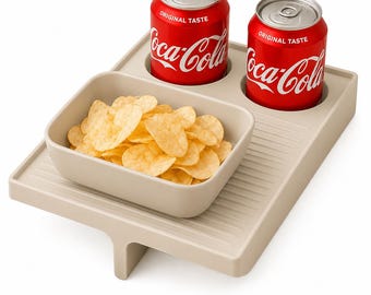 May include: A beige snack tray with a rectangular bowl filled with potato chips and two circular cutouts holding red Coca-Cola cans. The tray features a ribbed surface texture and a central support leg, providing a stable base for serving.