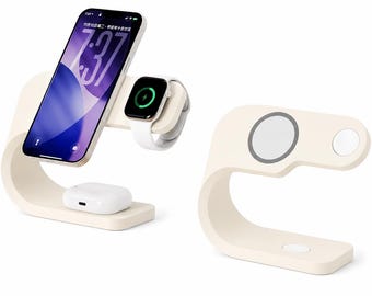 Op de afbeelding: Een crèmekleurige, C-vormige oplaadstandaard voor meerdere apparaten met een magnetische telefoonhouder, een zijwaartse horlogelader en een draadloos oplaadstation aan de basis. De standaard houdt een smartphone, smartwatch en oordopjes vast.