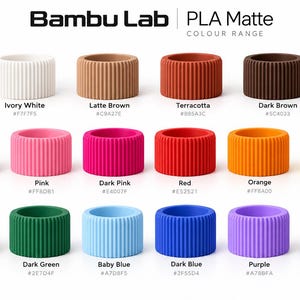 May include: Bambu Lab PLA Matte colour range chart featuring fifteen cylindrical, vertically ribbed 3D printing filament samples in various colors including ivory white, latte brown, terracotta, dark brown, sakura pink, pink, dark pink, red, orange, yellow, mint green, dark green, baby blue, dark blue, purple, and black.
