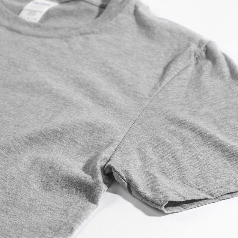 Pu&ograve; includere: Una t-shirt a maniche corte color grigio melange con scollo rotondo e un'etichetta bianca del marchio visibile all'interno del colletto. Il capo &egrave; realizzato in un tessuto a maglia morbido e testurizzato con cuciture visibili sulle maniche.