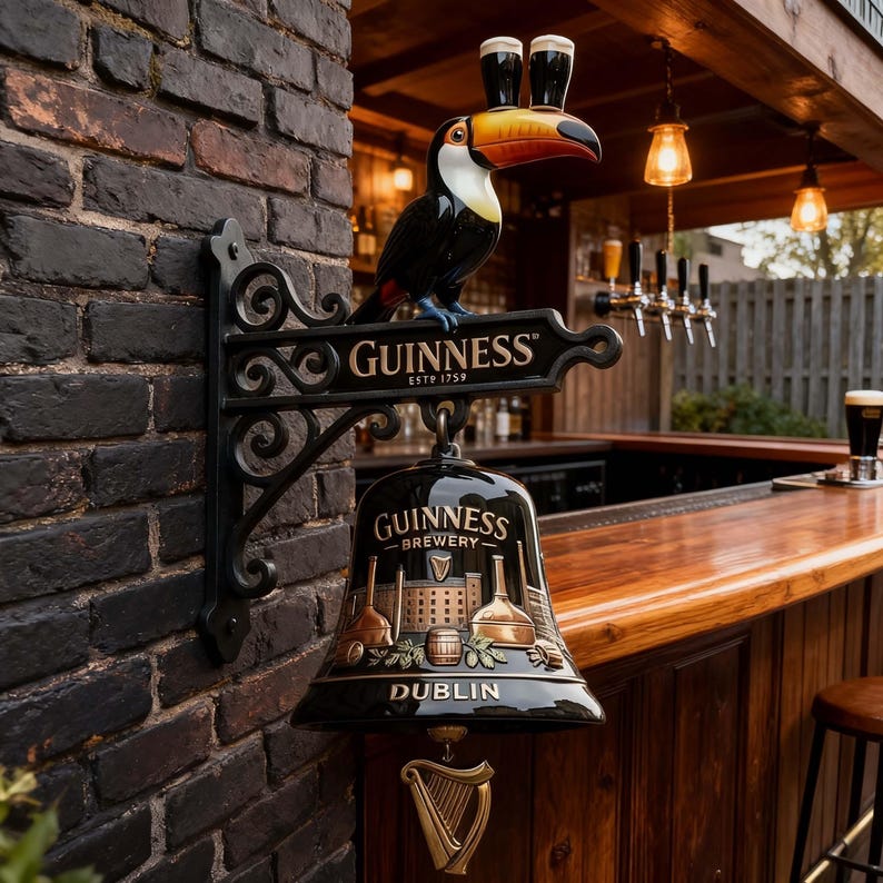 May include: A black Guinness Brewery sign with a toucan holding two glasses of stout. The sign is mounted on a brick wall and includes the text "Guinness Estd 1759" and "Dublin". A gold harp hangs below the bell.