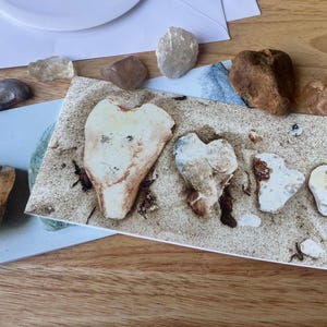 Juego de 2 tarjetas: una con una fotografía de piedras de los deseos y otra con una fotografía de piedras en forma de corazón (interior en blanco).