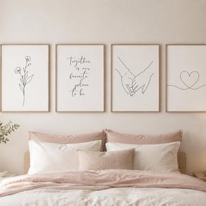Può includere: Quattro stampe artistiche incorniciate con disegni a tratto di un fiore, mani che si tengono, un cuore e la scritta "Together is our favorite place to be". Le stampe sono in una camera da letto sopra un letto con biancheria da letto rosa.