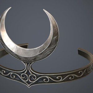 May include: A silver-coloured crescent moon-shaped headpiece. The headpiece features an open crescent moon design with etched detailing, connected to a band with an ornate, swirling pattern. The overall design is elegant and suitable for themed events.