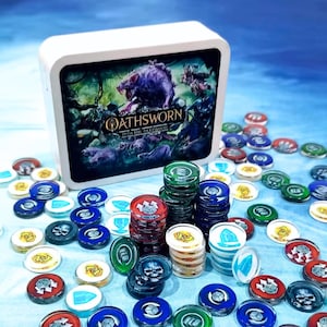 Op de afbeelding: Een witte doos met de speltitel Oathsworn Into The Deepwood en een illustratie van een donker wezen, omringd door talloze doorschijnende plastic spelfiches in rood, blauw, groen en wit, elk gemarkeerd met verschillende symbolen en iconen.