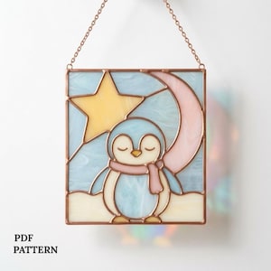 May include: Stained glass panel featuring a sleeping penguin with a pink scarf, set against a light blue background with a yellow star and pink crescent moon. The panel is framed in copper and suspended by a chain. The text "PDF PATTERN" is at the bottom.