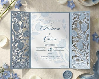 Könnte beinhalten: Eine dreifach gefaltete Hochzeitseinladung mit filigranen, lasergeschnittenen blauen Tulpenmustern auf den Seitenteilen. Das Mittelteil enthält den Text: Please join us to celebrate the wedding of Haroon & Olivia, Saturday November 28, 2026.