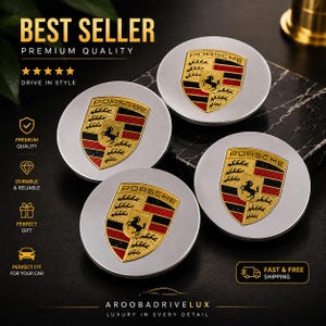 May include: Four circular silver wheel center caps featuring the gold, black, and red Porsche crest emblem. Each cap displays the Porsche logo at the top of the shield with a central black horse and horizontal stripes. The design is metallic and smooth.