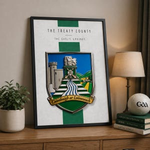 May include: Framed artwork featuring the Limerick coat of arms, with a silver emblem set against a white and green striped background. The text "THE TREATY COUNTY" and "THE GAELIC GROUNDS" are displayed above the emblem. The artwork is in a black frame.